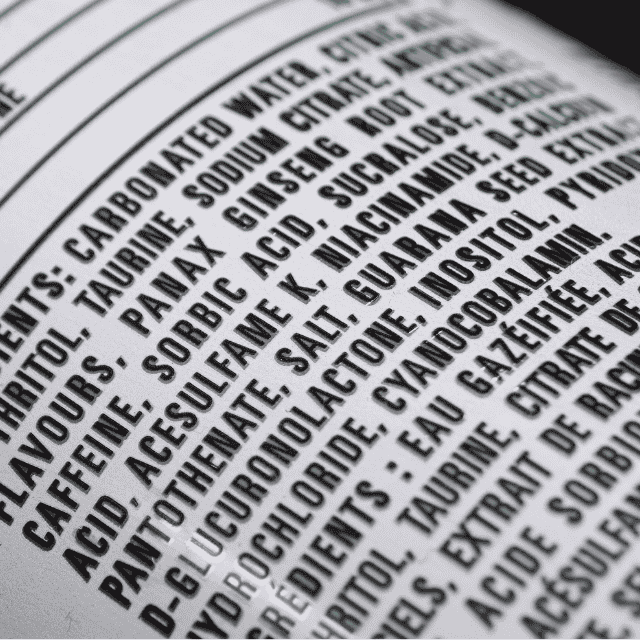 Close-up of a packaged drink’s ingredient list showing additives and sweeteners, illustrating ultra-processed foods.